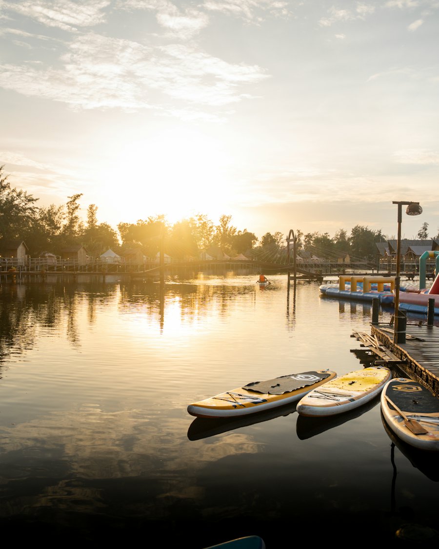 Sunrise over a lake with paddleboards at the dock